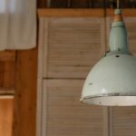 Een stijlvolle metalen hanglamp boven een eettafel in een modern interieur met warm licht.