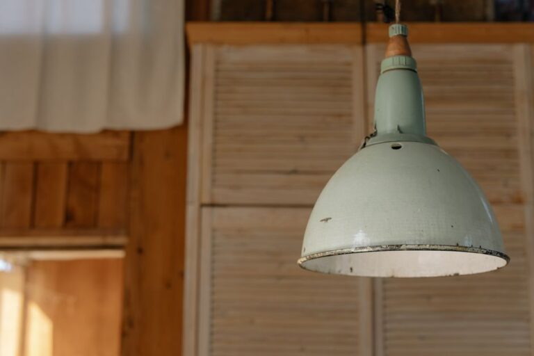Een stijlvolle metalen hanglamp boven een eettafel in een modern interieur met warm licht.